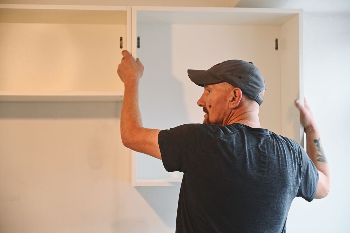 Joiner fitting kitchen wall units in a Glenrothes home
